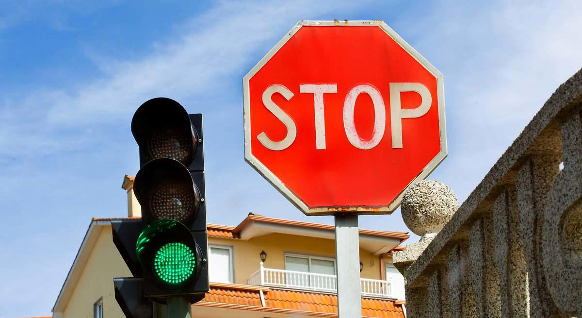 En un cruce con una señal y un semáforo, a qué hay que hacer caso: la regla que muchos conductores confunden