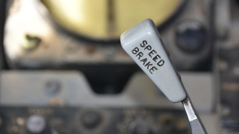 How do airplane speed brakes work and how do they differ from spoilers?