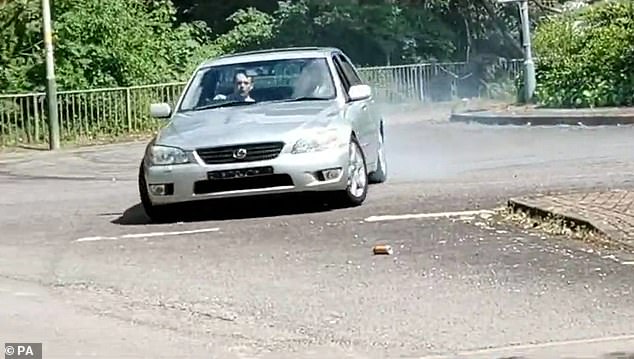 driver caught on video spinning his car the wrong way around roundabout is banned from roads