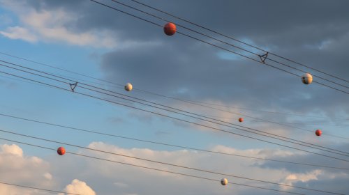 The Reason Power Lines Have Orange Balls Is Almost As Interesting As How They Get There