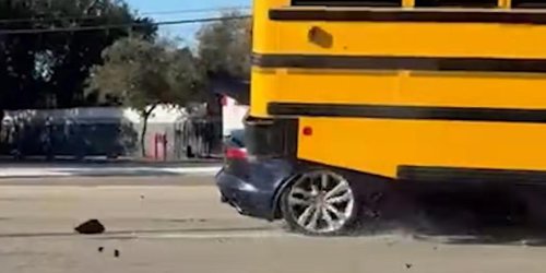 Un jaguar choca contra un autobús escolar y queda atascado debajo