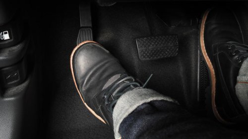 What does 'riding the clutch' mean on a manual car?