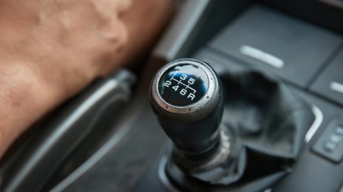 What does 'riding the clutch' mean on a manual car?