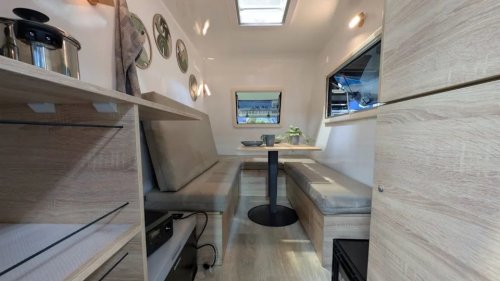 This tiny trailer hides a full camper experience inside – including a lounge and dining area